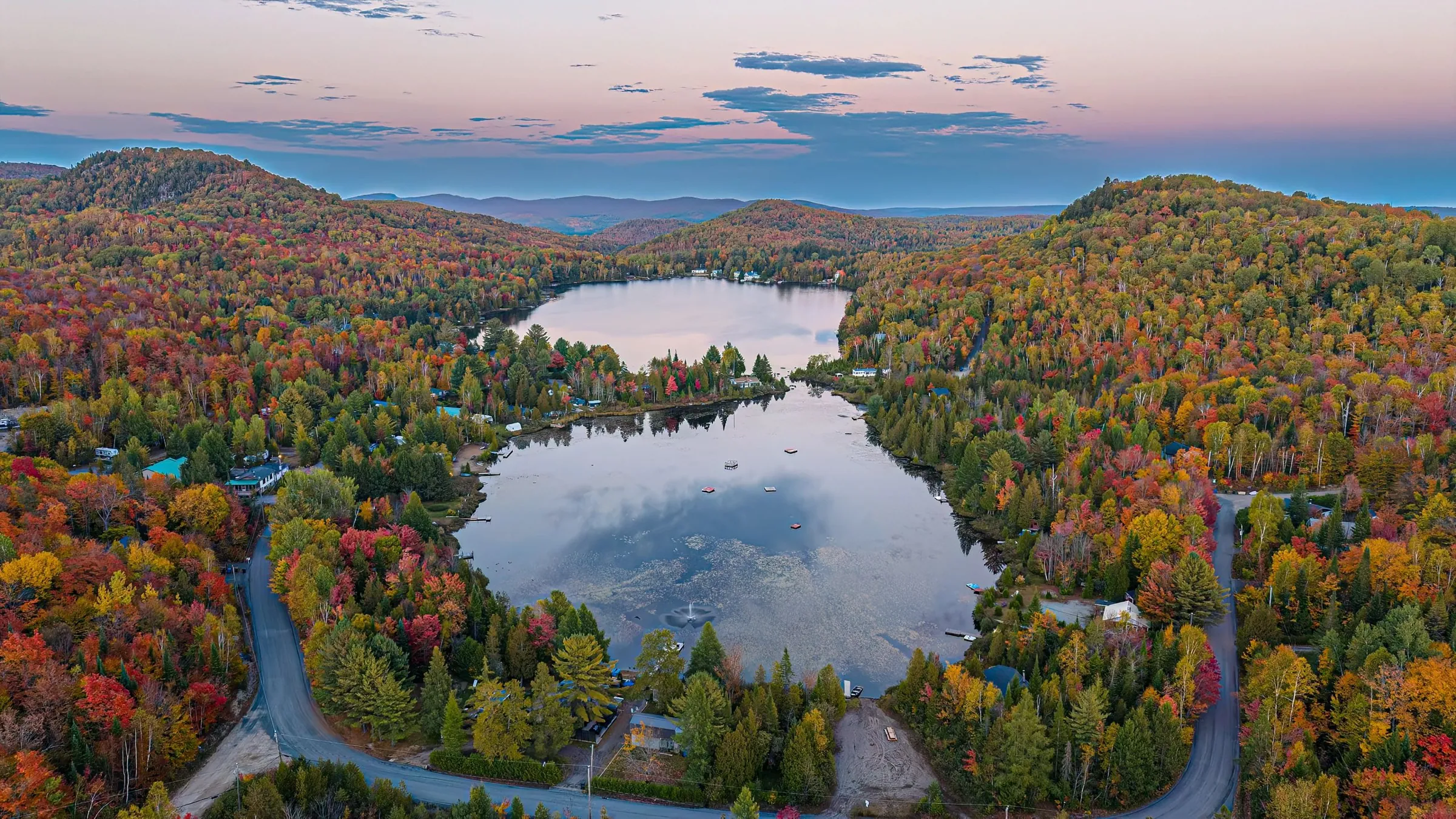 Vue par drone du lac Barron à Gore, près de Morin-Heights dans les Laurentides : lac, forêt et montagnes en fin de journée